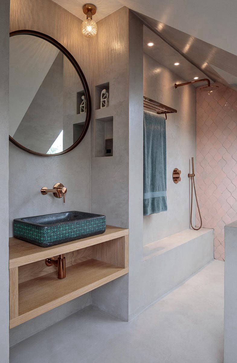 Light-coloured bathroom walls around a basin with timber shelving