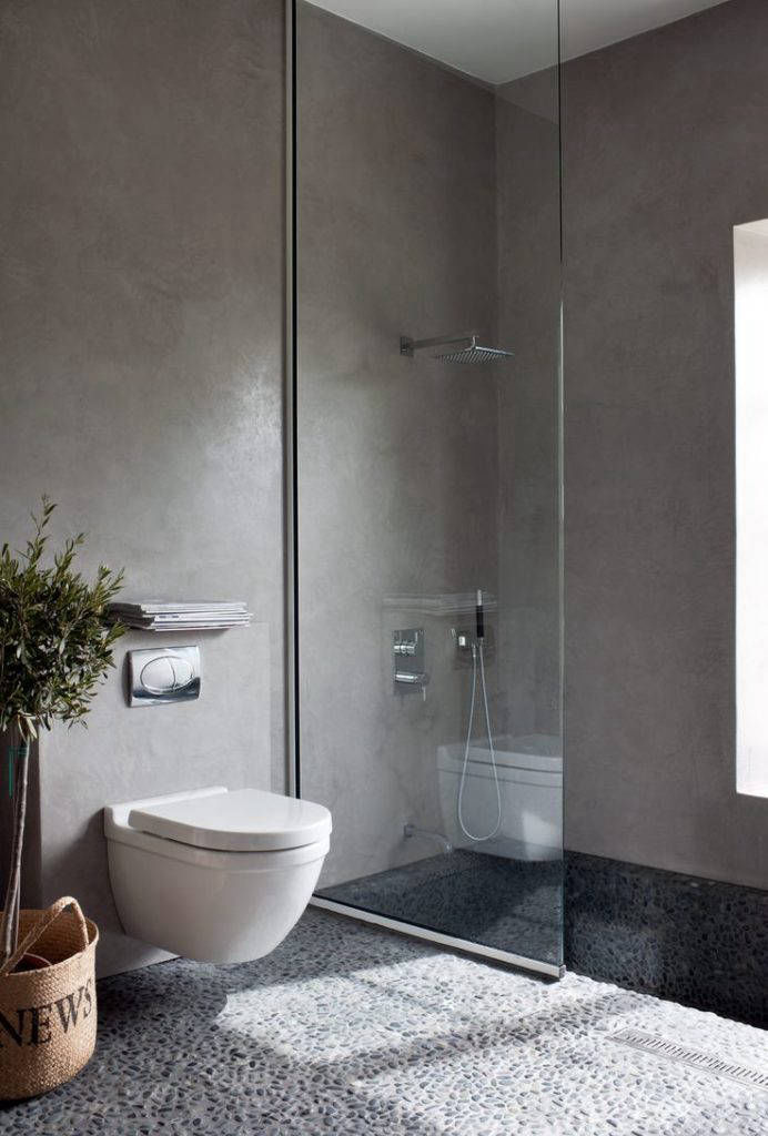 Grey walls and dark shower flooring behind a glass screen