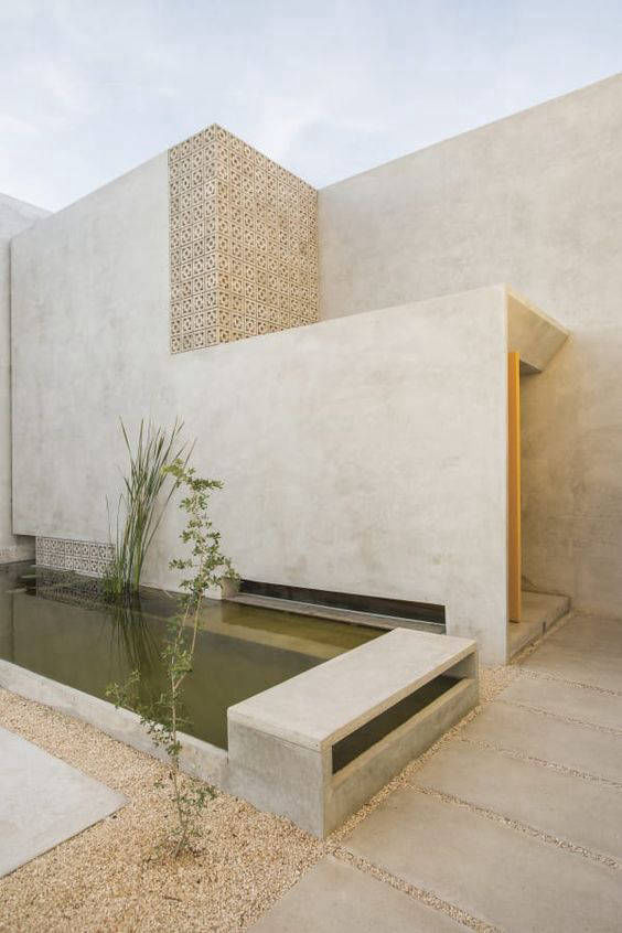 Reflecting pool and integrated wall seating in a light-toned courtyard