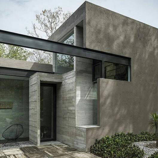 Glazed connecting space between grey façade walls