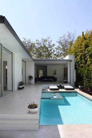 Pool terrace and broad steps in front of a white house façade