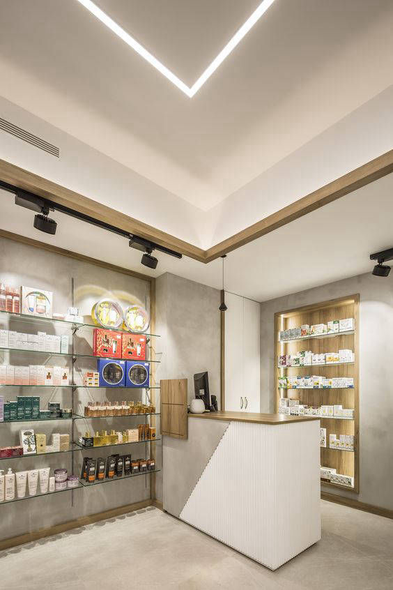 Light-coloured sales counter and grey flooring in front of illuminated shelves