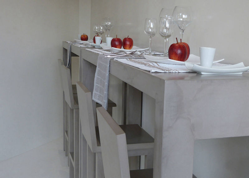 Long light-coloured bar table with white stools