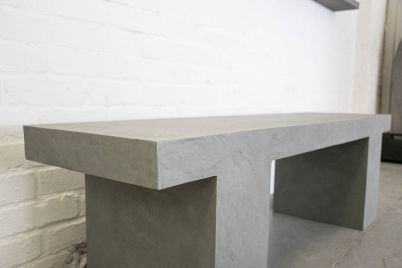 Grey console with a thick top against a white brick wall