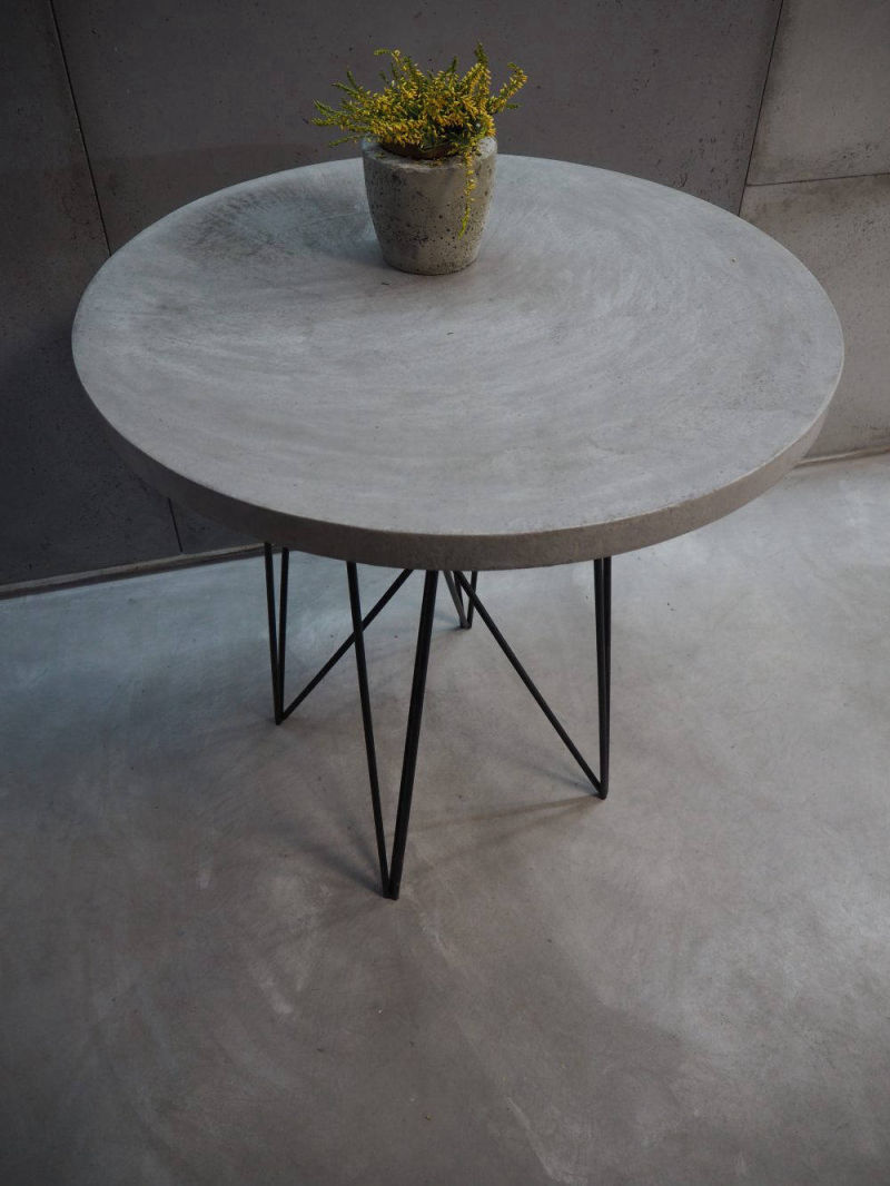 Round grey table with slender black metal legs