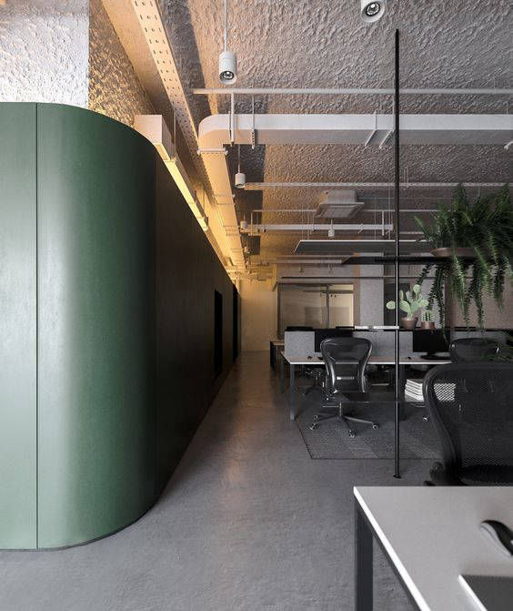 Grey flooring in an open office beside a green partition wall