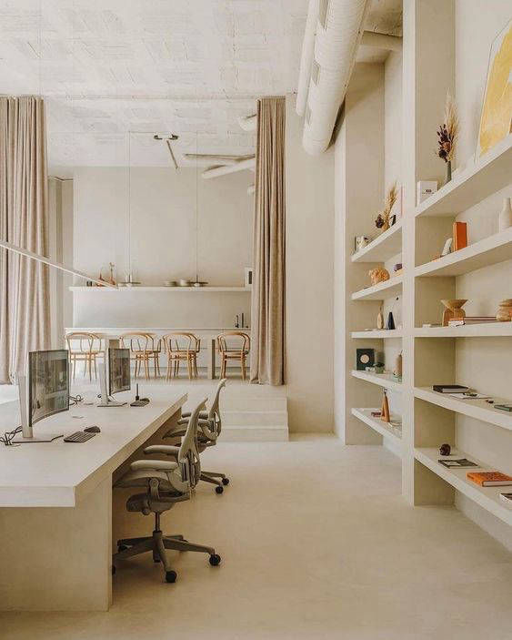 Light-coloured office flooring between open shelves and desks