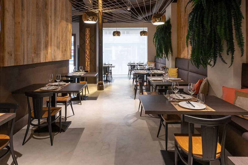 Light grey passage flooring between tables in a timber-walled restaurant