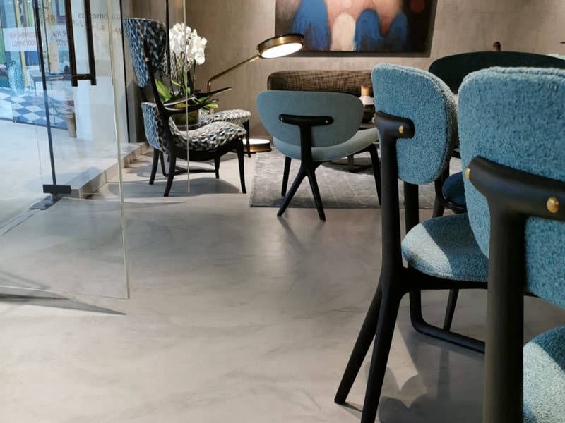 Grey flooring in a restaurant seating area with blue upholstered seats